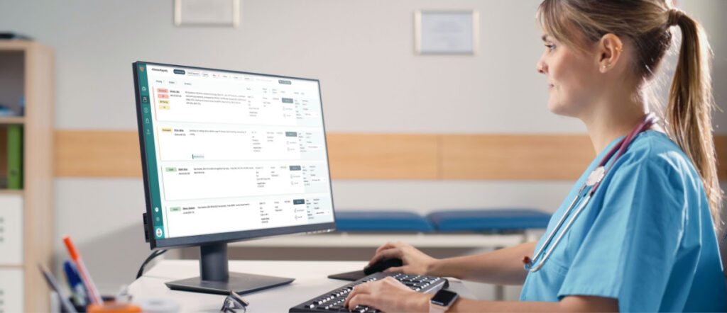 Medical professional sitting at desk with vector platform on desktop computer